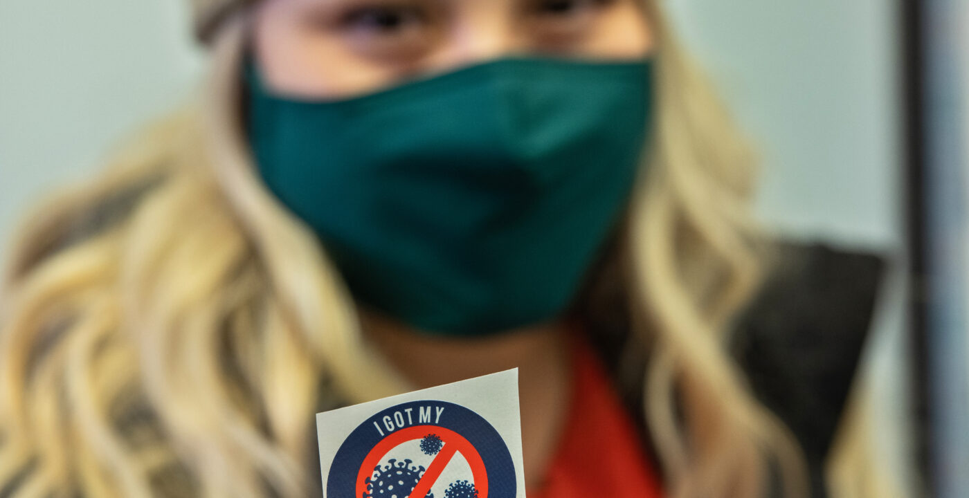 Patient in mask receiving Covid-19 vaccine.