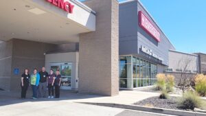 Group of medical workers standing in front of a hospital.