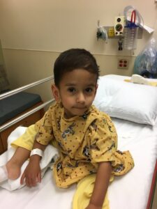 Small boy sits in hospital bed