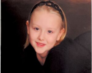 Young girl in headband smiles for camera