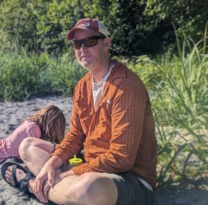 A man sitting on a log. 