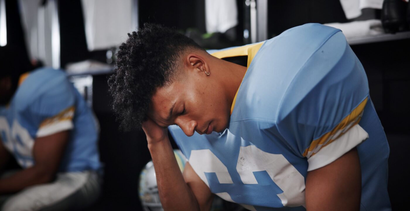 Young football player holding his head