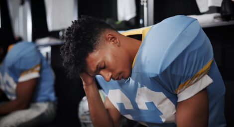 Young football player holding his head