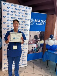 Teenage girl who participated in M.A.S.H. Camp holds her certificate