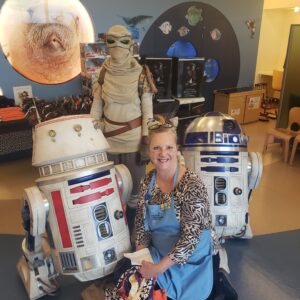 Woman posing with Star Wars characters.