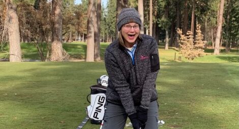 Happy woman playing golf