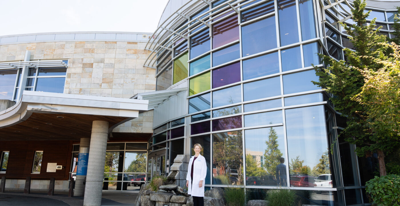 Woman poses for photo in front of medical building