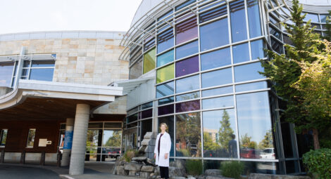 Woman poses for photo in front of medical building