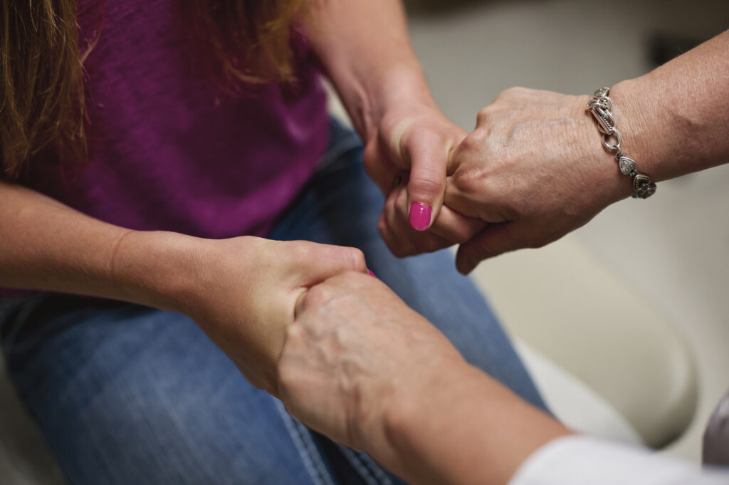 Woman squeezing another woman's hands