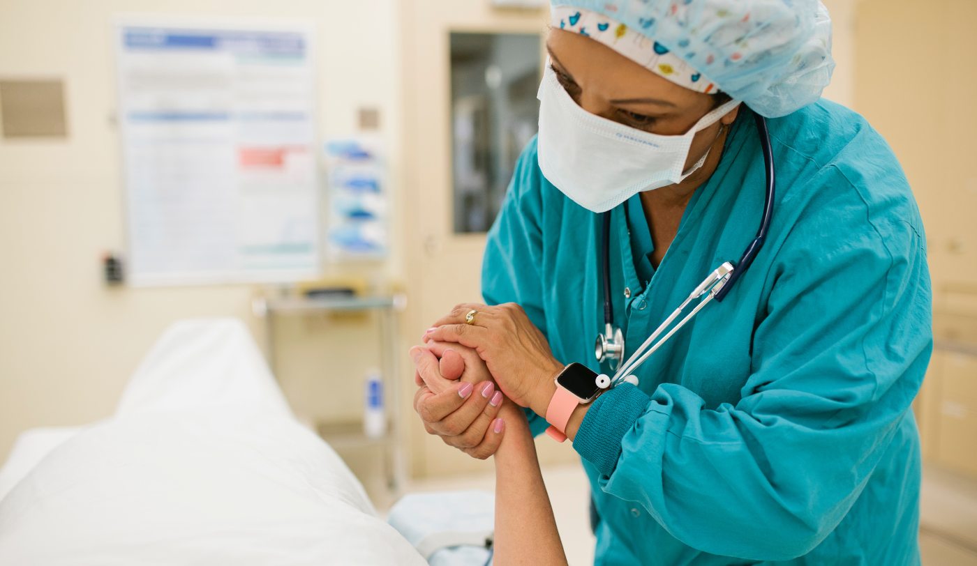 Member of surgical staff comforts patient.