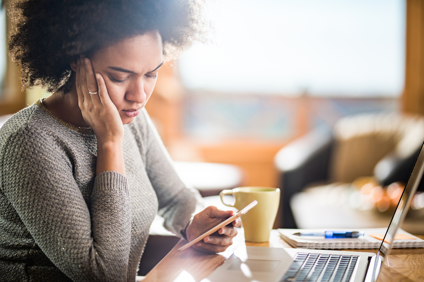 Young woman with a concerned expression reading a text on her phone