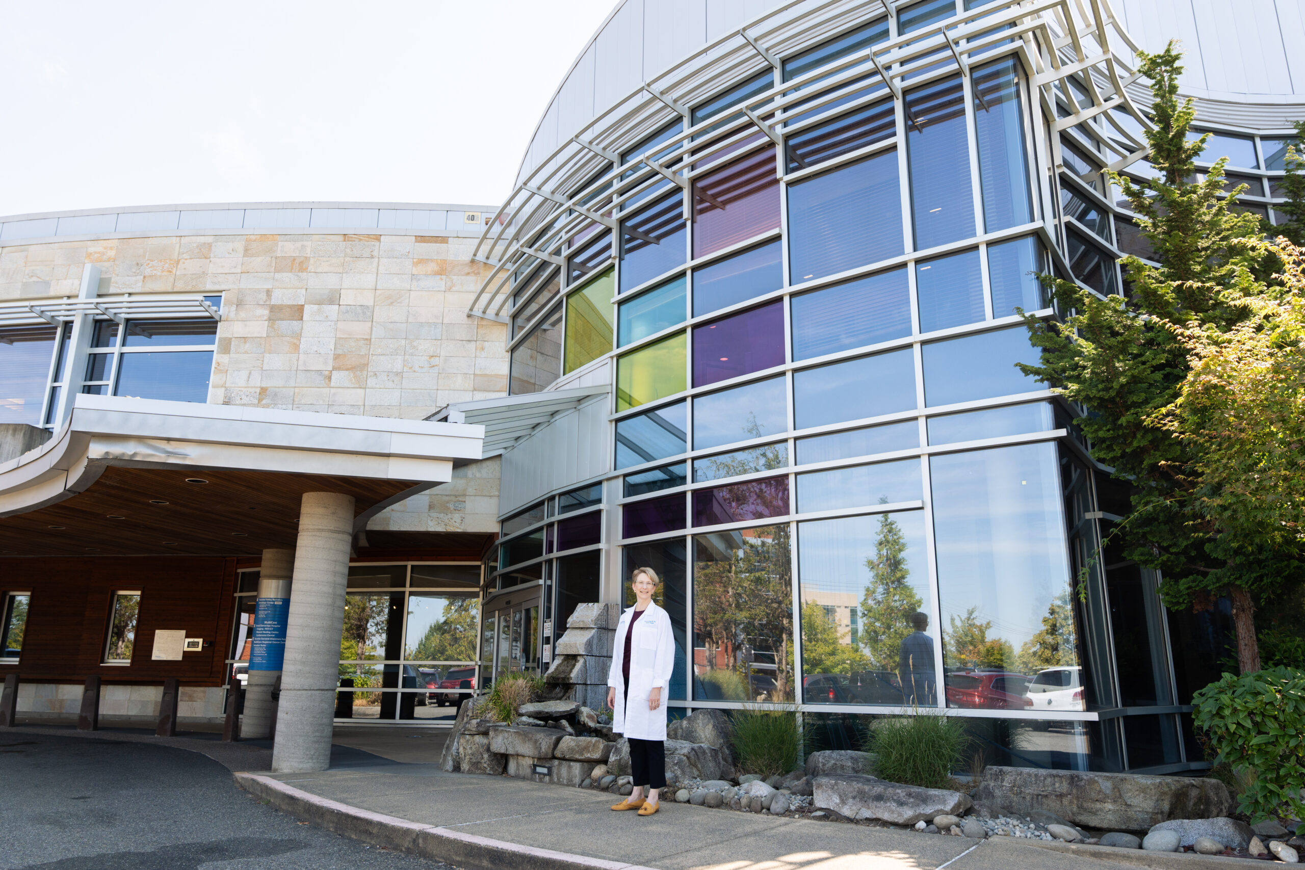 Woman poses for photo in front of medical building