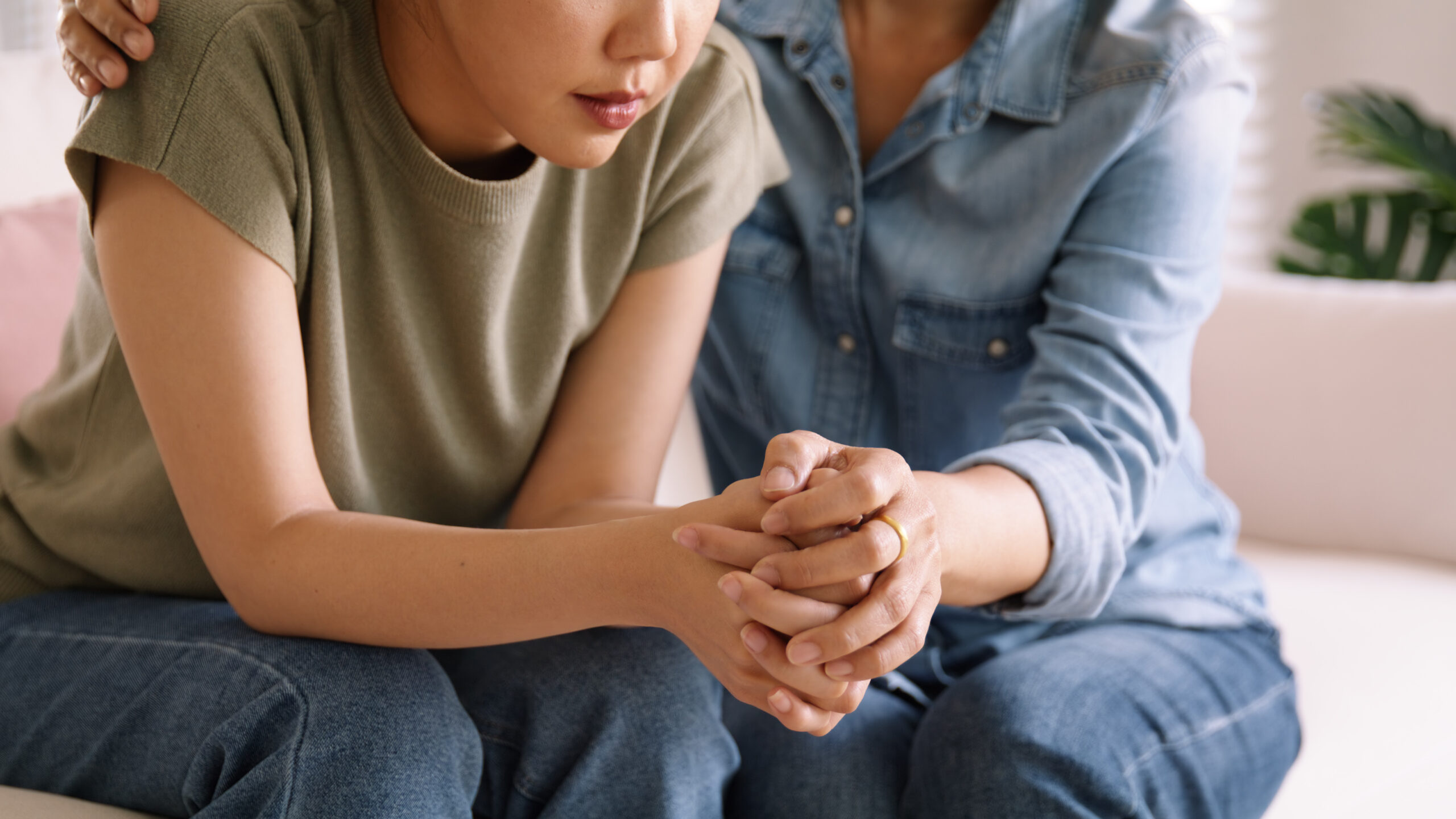 One person holding another person’s hands in comfort